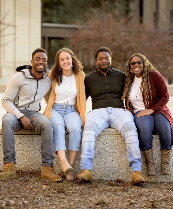 A group of people sitting in a park under sunlight with a blurry background